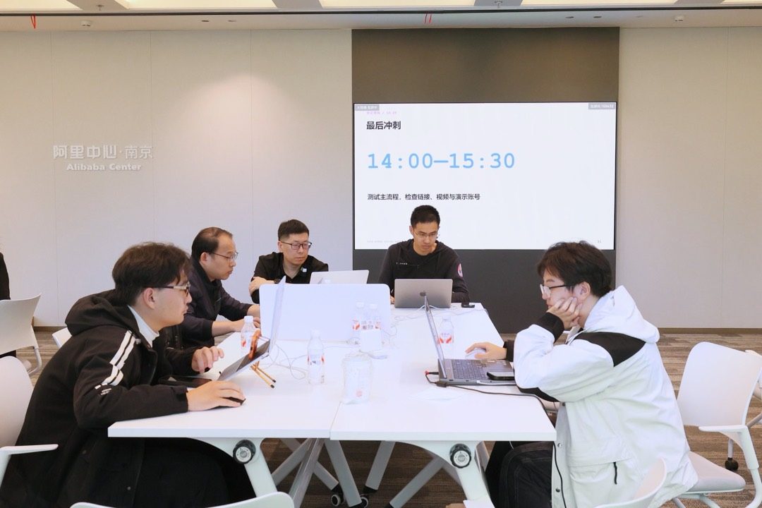 大屏显示「最后冲刺 14:00—15:30」,各参赛团队在桌前做收尾开发