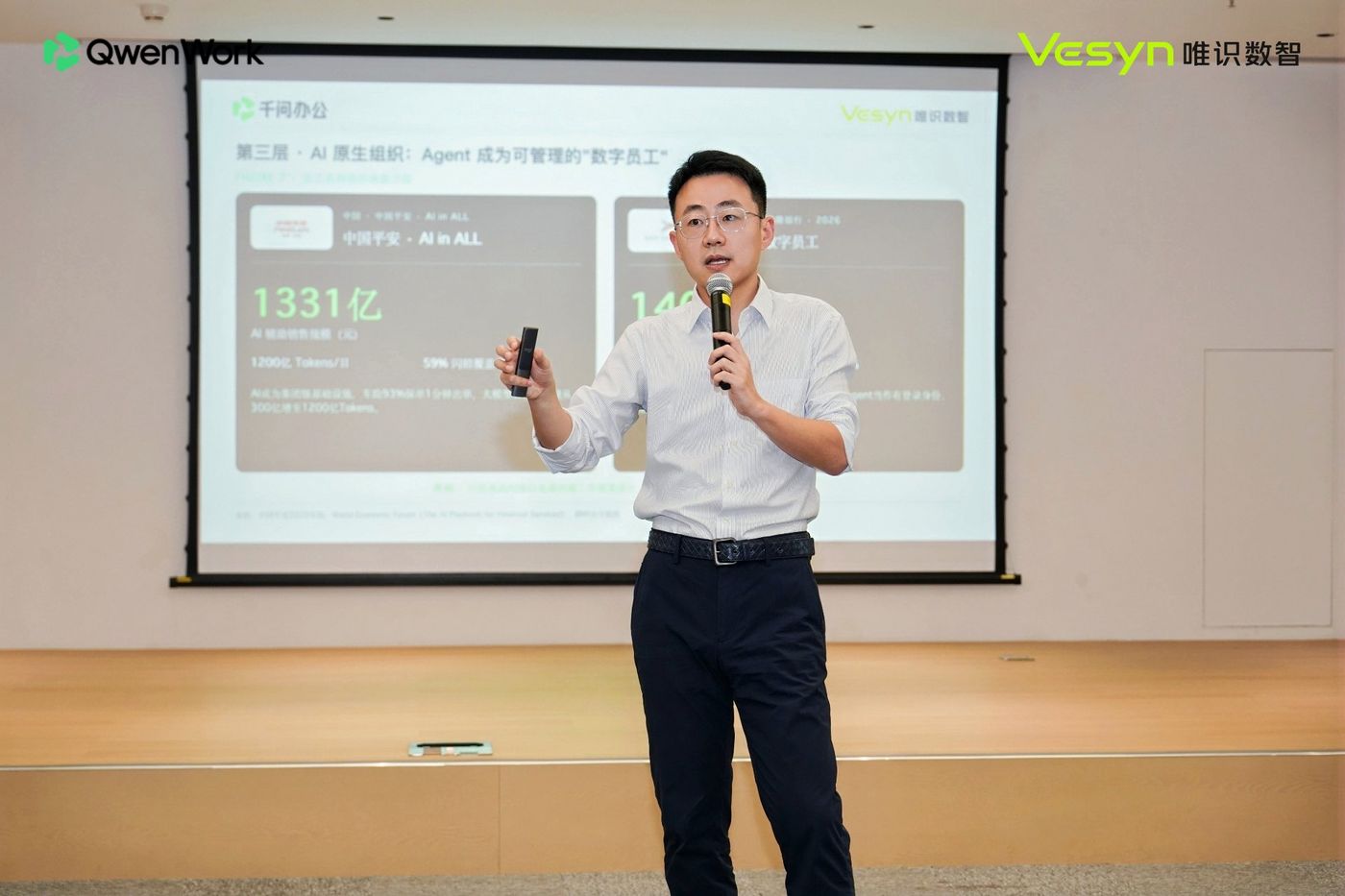 分享嘉宾在台上讲解 AI 落地保险的第三层:AI 原生组织,大屏展示相关案例数据